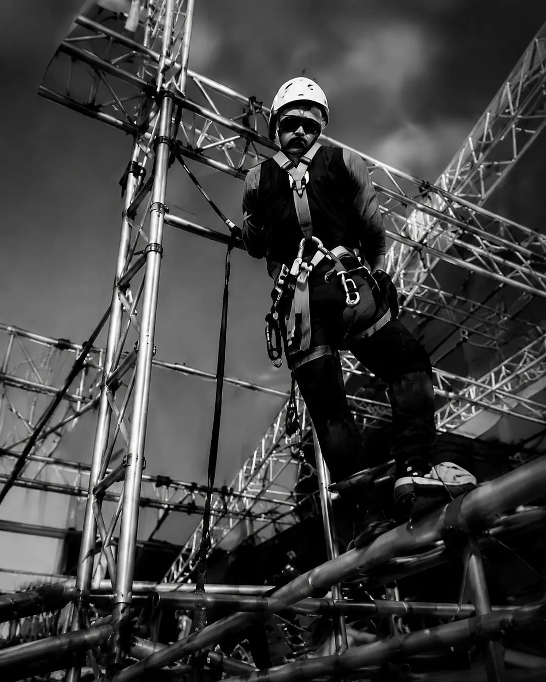 Especialista en montaje trabajando en altura con arnés y equipamiento de seguridad